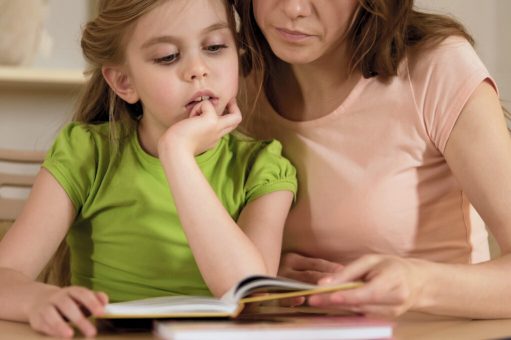 Supportive mother reading textbook together with hyperactive little daughter, stock footage